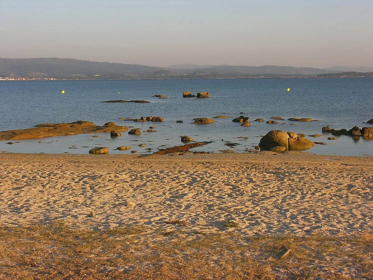 Playa de O Vao con pasarela de madera y ducha, y la ría de Arousa al fondo