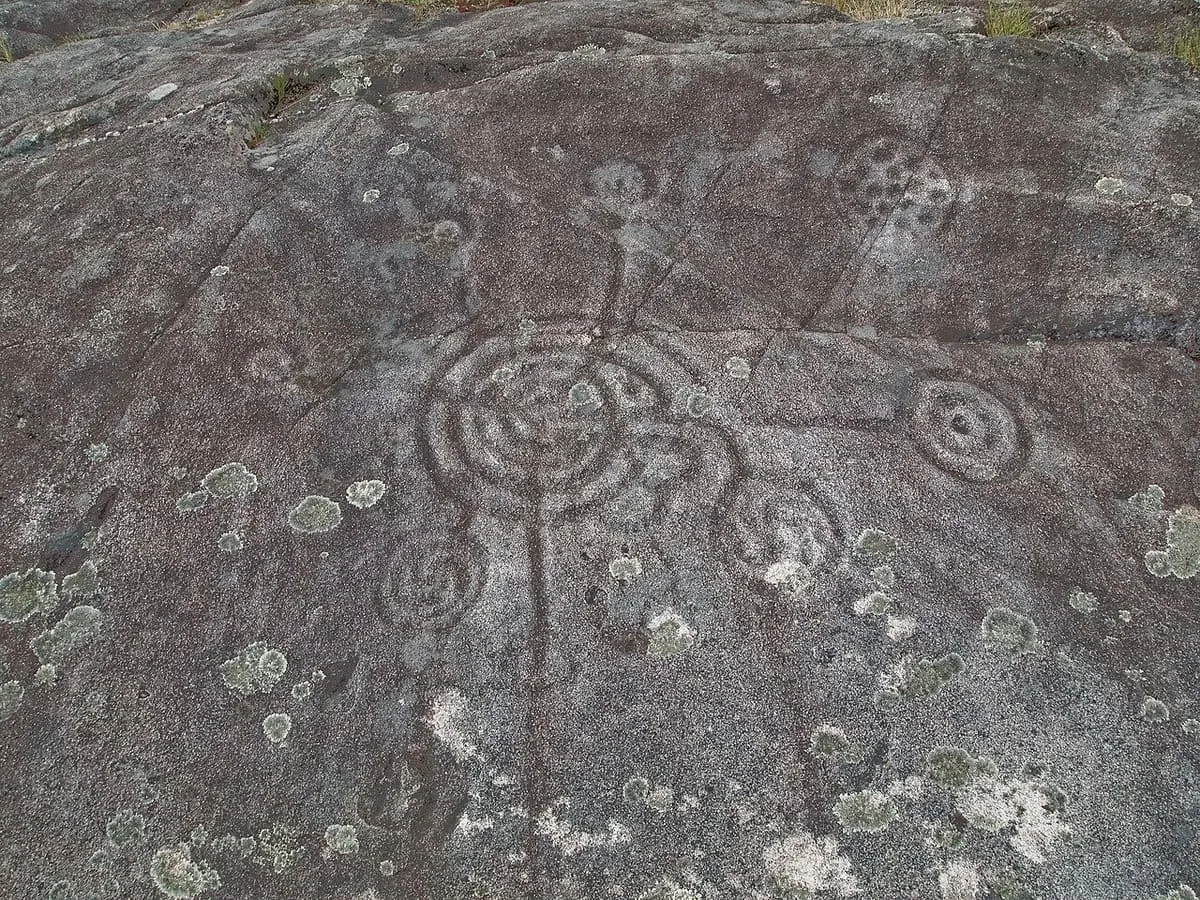Círculos concéntricos grabados en una roca cubierta de líquenes, en la Laxe das Cruces