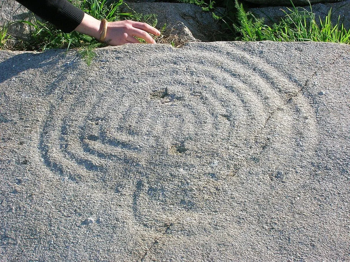 El laberinto grabado en la Pedra do Labirinto de Mogor, con surcos concéntricos y una cazoleta
