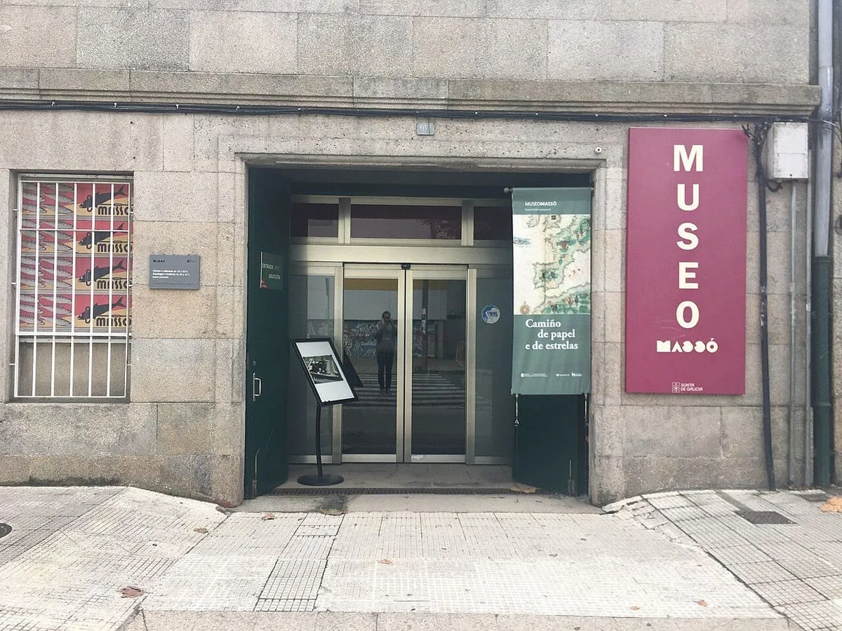 Entrada de cristal del Museo Massó con el cartel del museo