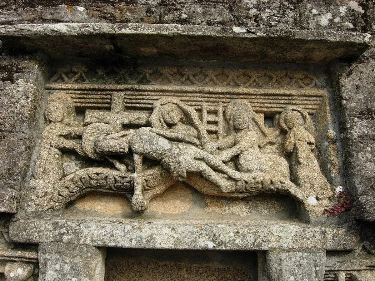 Relieve de piedra del baldaquino con figuras tallado en un muro, incrustado en la pared junto a la plaza