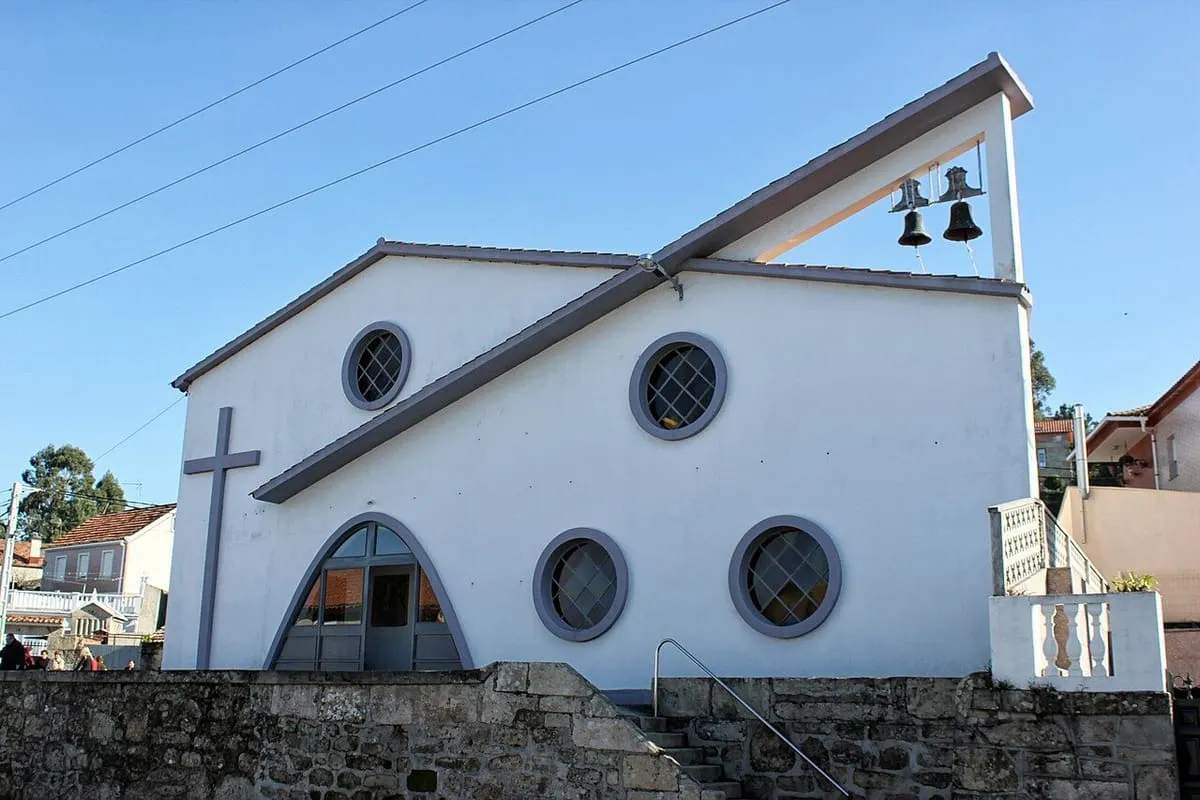 Iglesia blanca con espadaña y ventanas redondas en Mogor