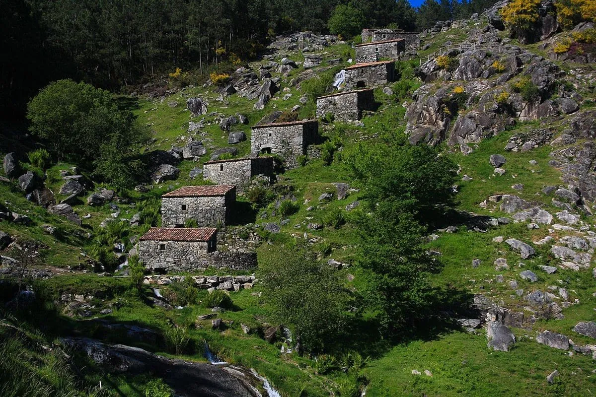 Molinos de piedra escalonados en la ladera, con el arroyo bajando entre las rocas
