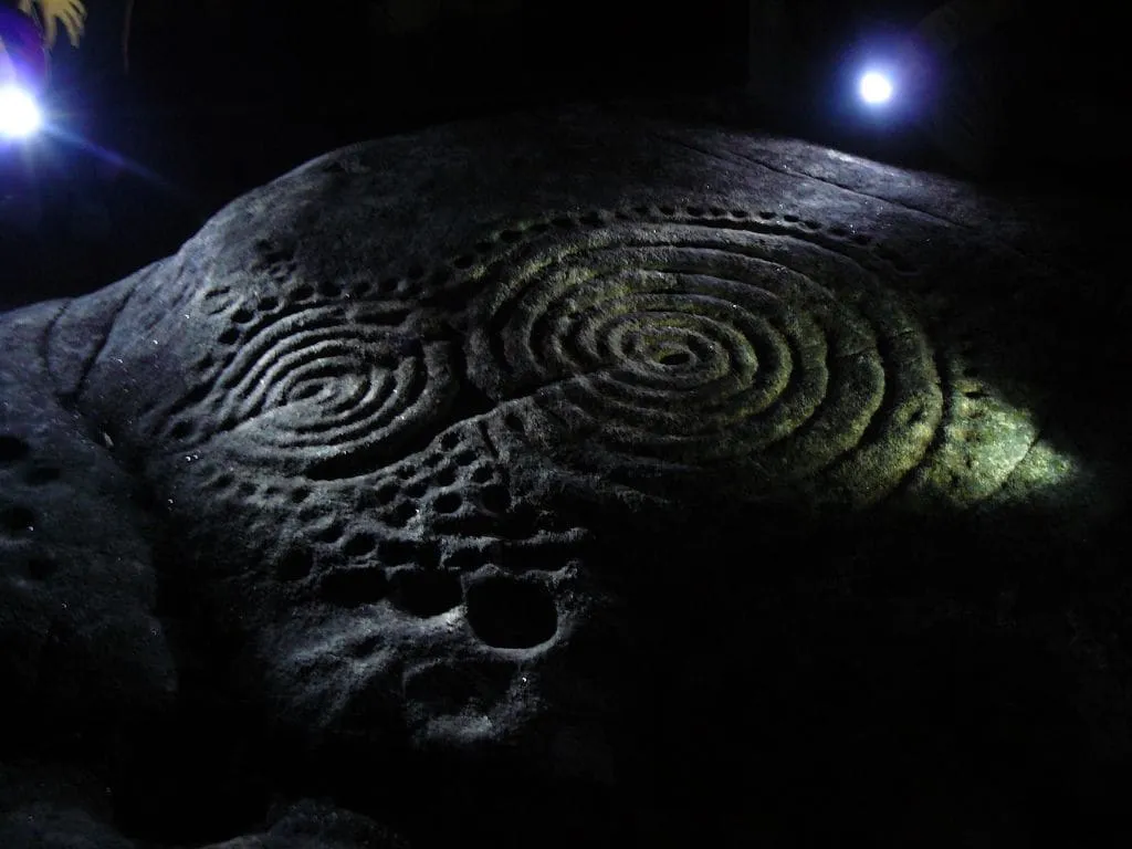 Doble espiral de la Laxe das Rodas iluminada de noche, con pequeñas cazoletas alrededor