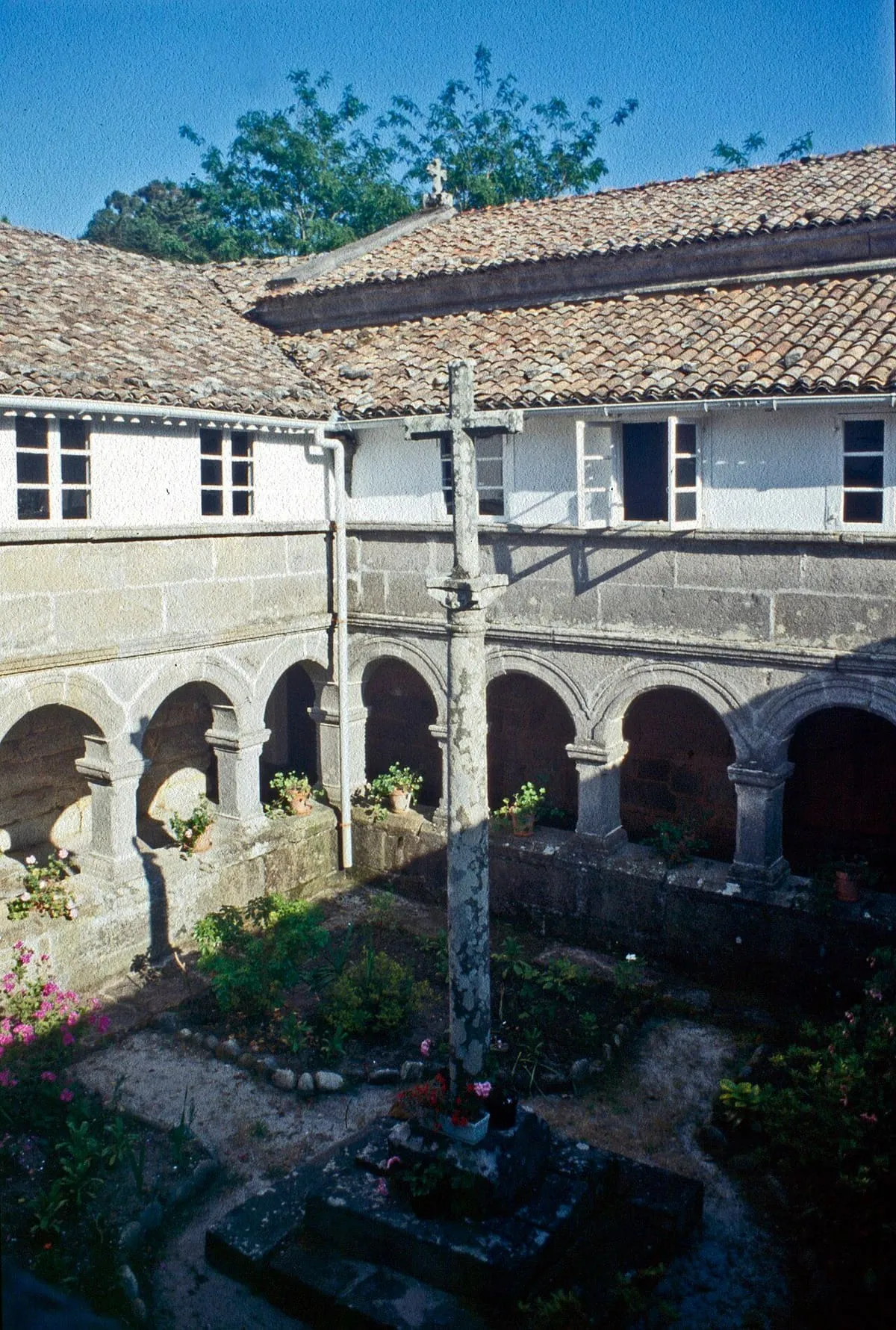 Claustro de arcos de granito del convento de San Francisco de Louro, con una cruz de piedra