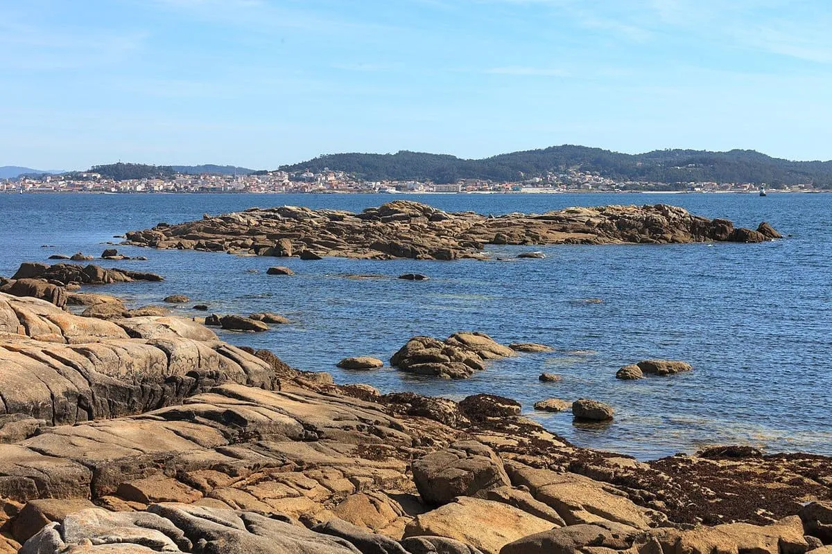 Costa de rocas y arena de O Carreirón, con la ría de Arousa al fondo