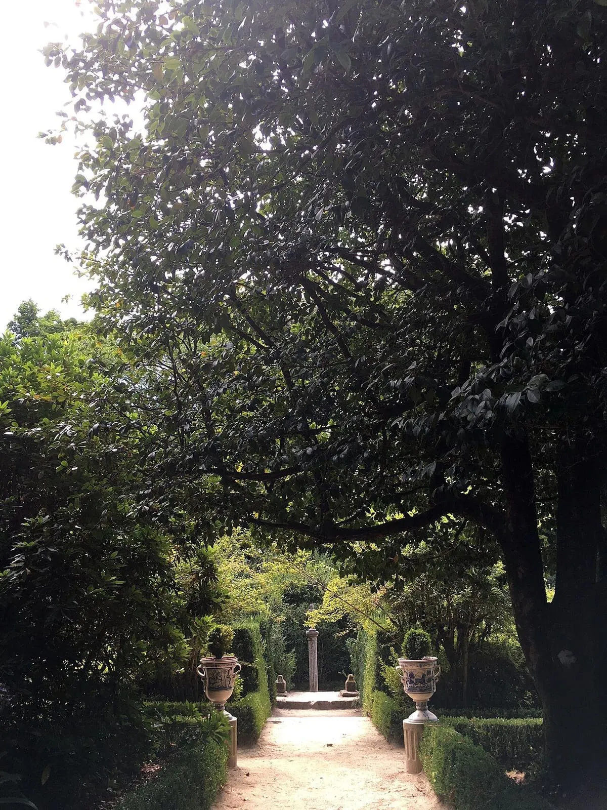 Paseo del jardín del pazo de Oca entre setos y árboles
