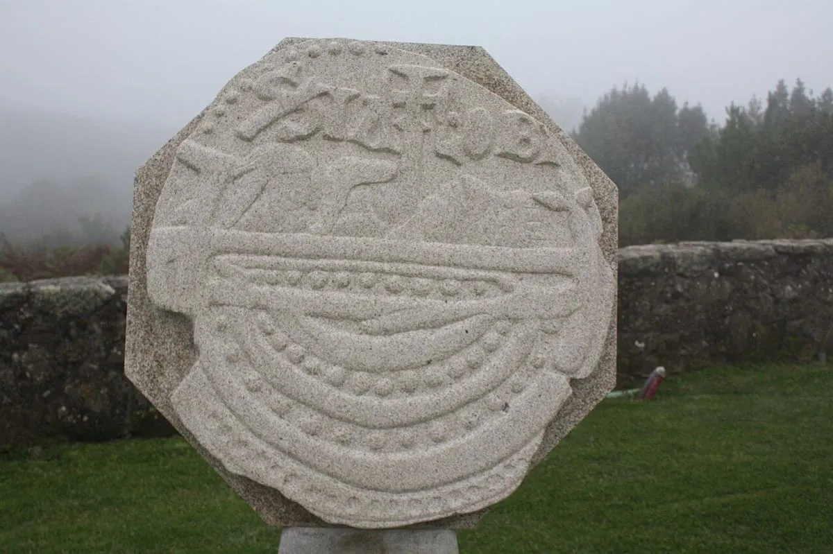 Monumento de piedra con forma de moneda con un relieve, que recuerda la translación del cuerpo del apóstol Santiago