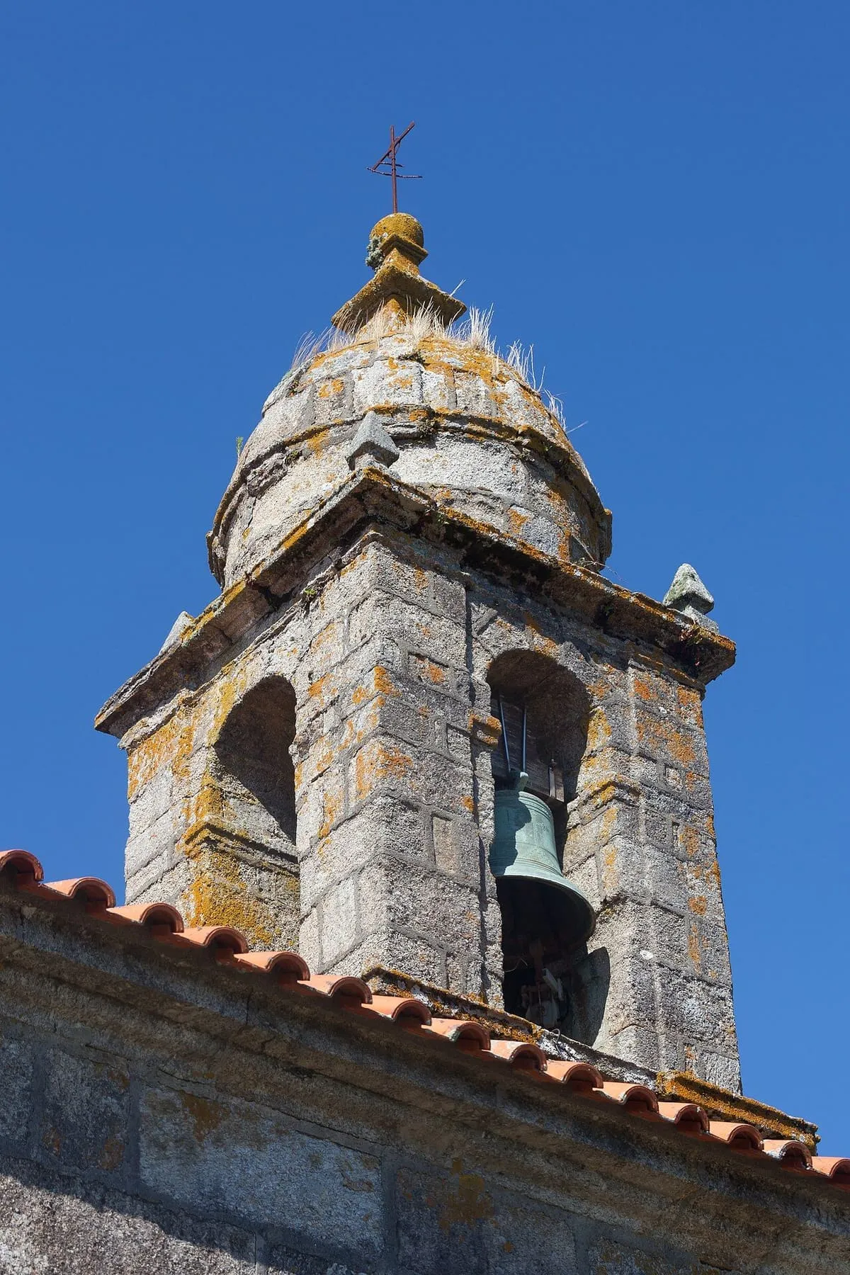 Campanario de piedra de San Martiño do Grove con decoración de placas y una cúpula