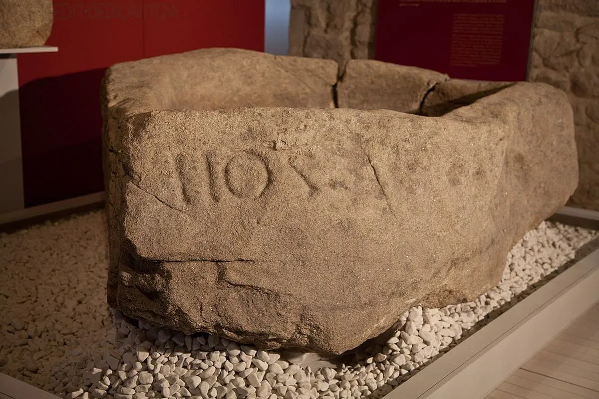 Detalle de la pía de Mougás con letras latinas grabadas en un lateral de la piedra