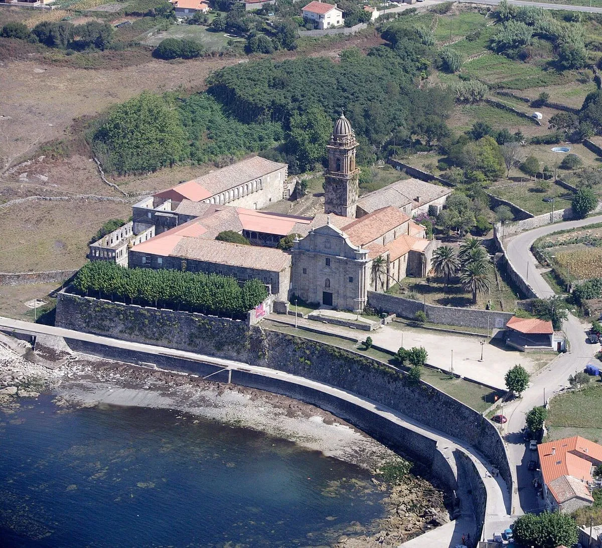 Vista aérea del conjunto del monasterio de Oia, junto a la ensenada y el muro de la costa