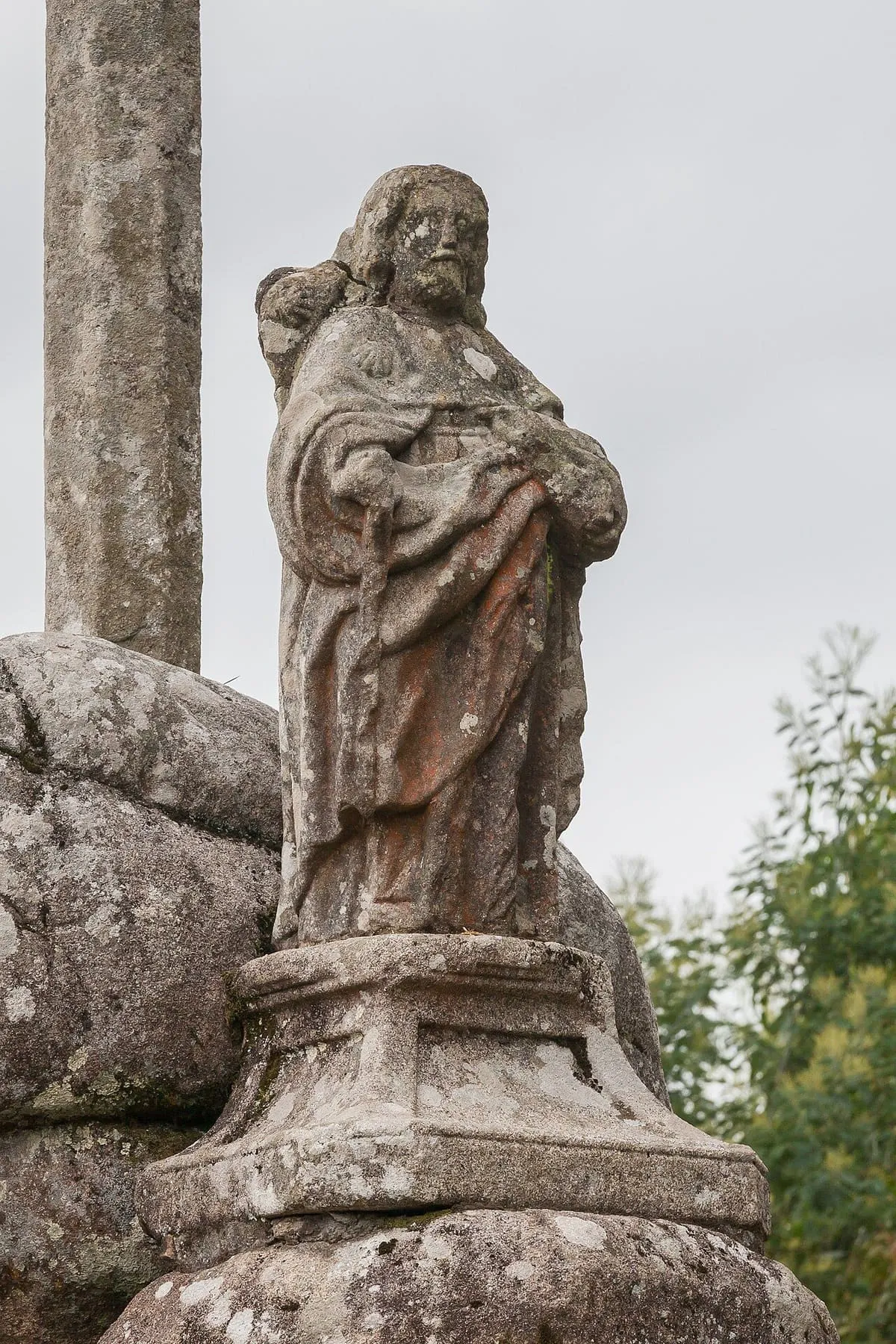 Imagen del apóstol Santiago tallada en piedra, junto a rocas, en Santiaguiño do Monte