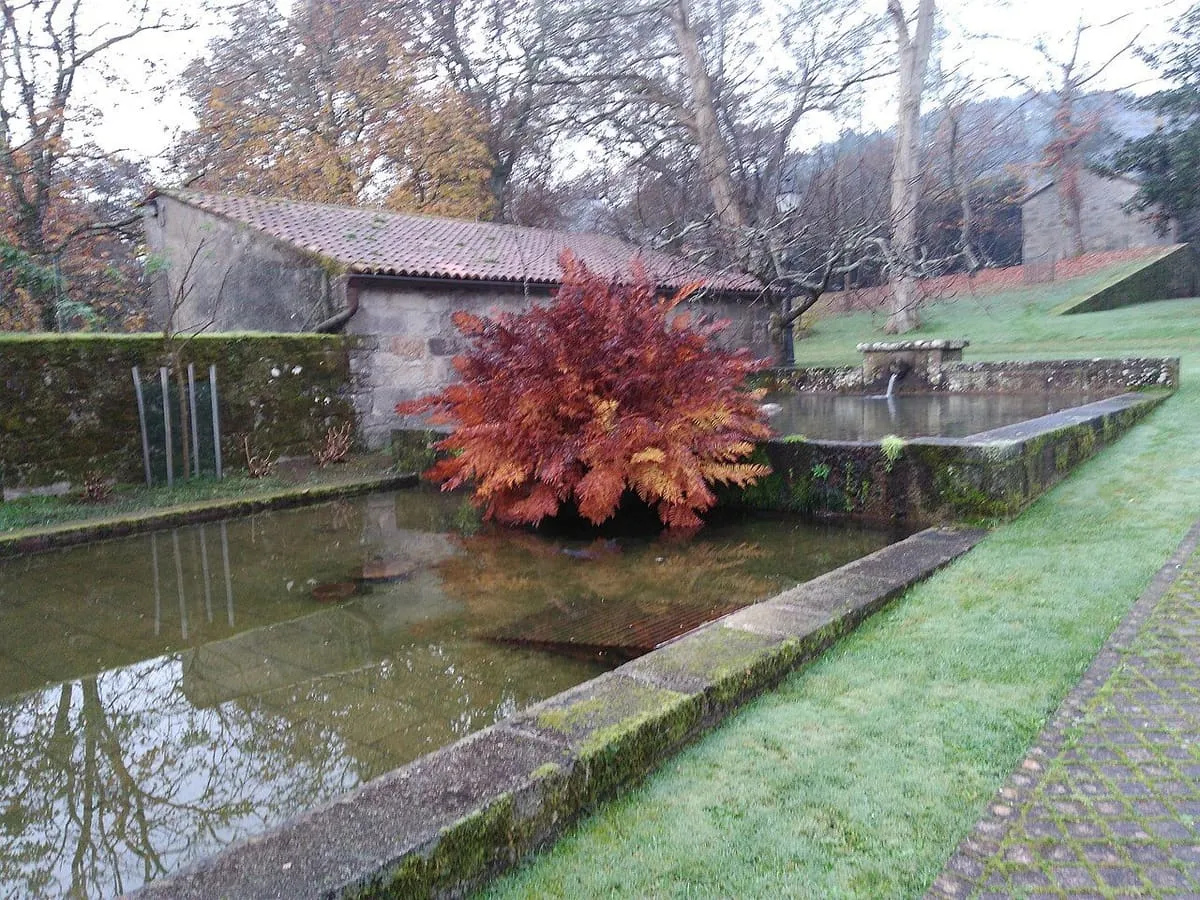 Un estanque con una fuente de piedra en los jardines de la Torre do Monte