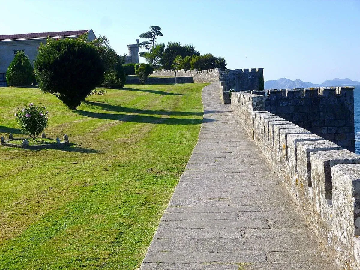 Paseo empedrado sobre la muralla de Monterreal, junto a una explanada de hierba