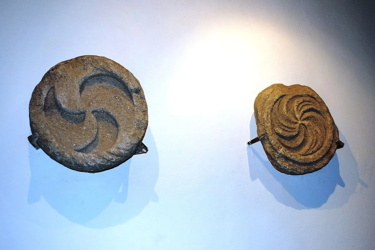 Dos discos de piedra con motivos curvos grabados, colgados en la pared del museo arqueológico del monte Santa Trega