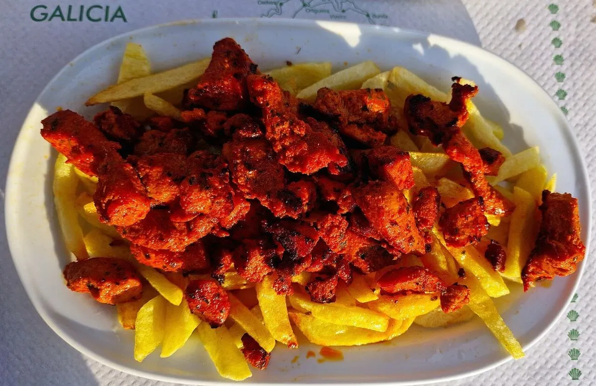 Un plato de zorza, carne de cerdo adobada con pimentón, con patatas fritas