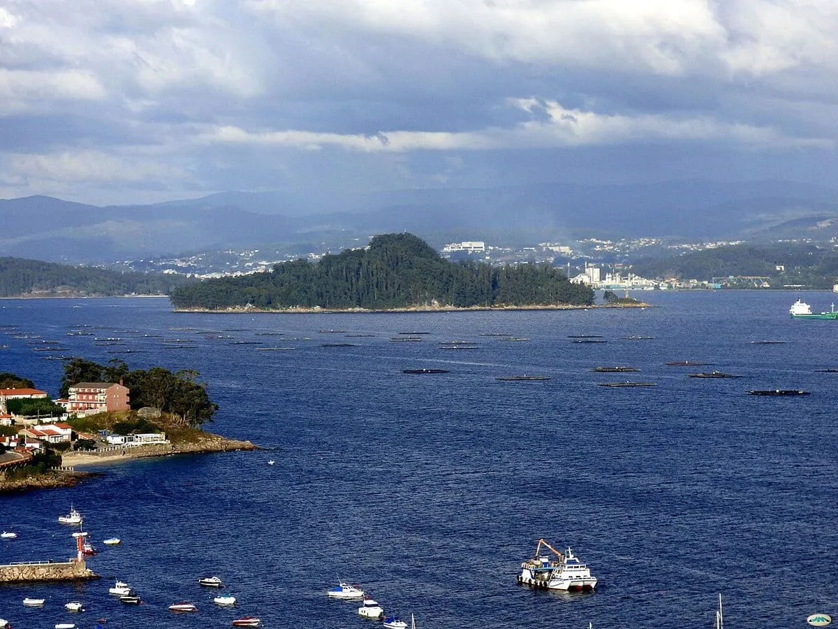 La isla de Tambo vista desde la ría con pequeñas embarcaciones en primer plano