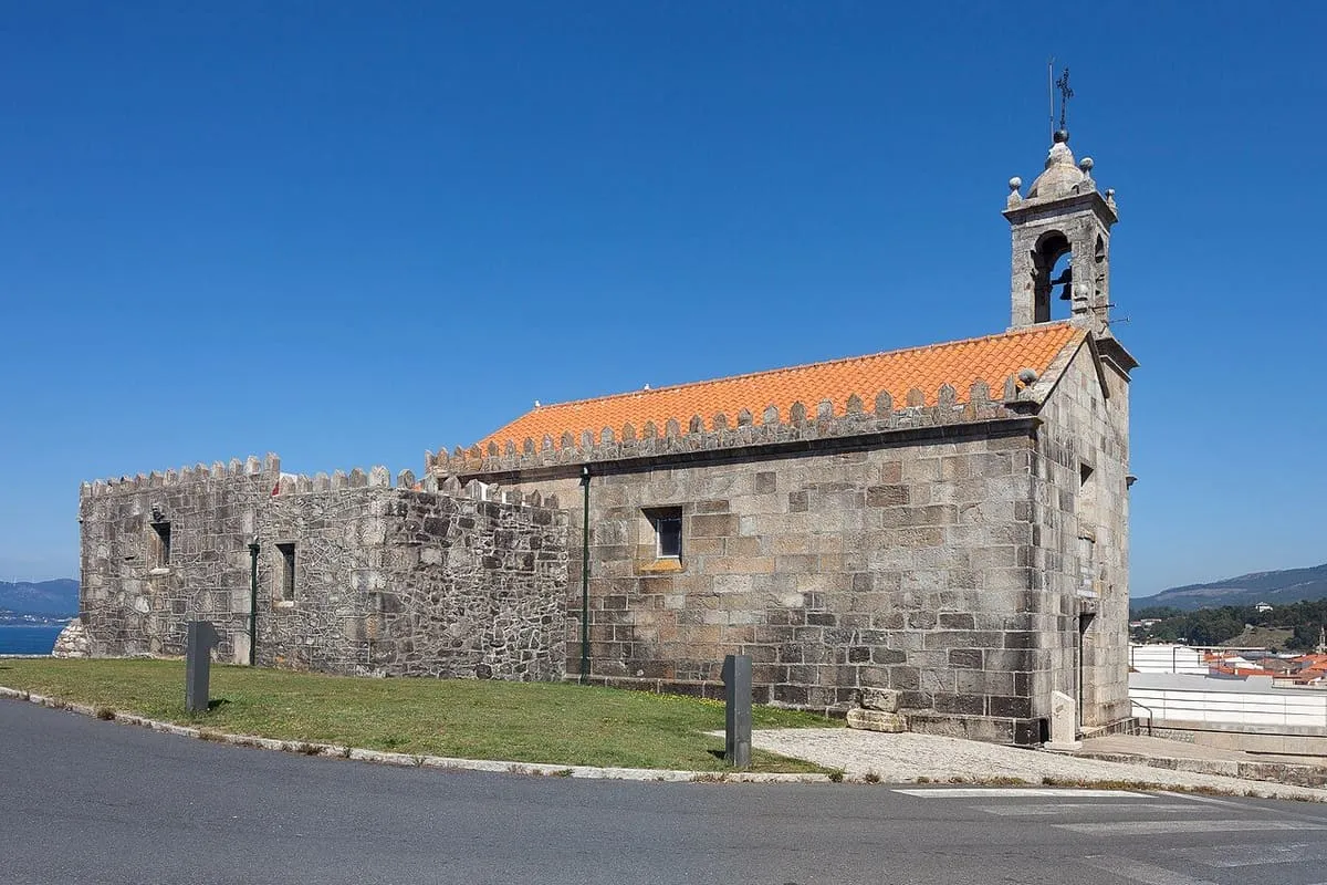 La capela da Atalaia vista de lado, con su muro bajo de piedra y el tejado de teja