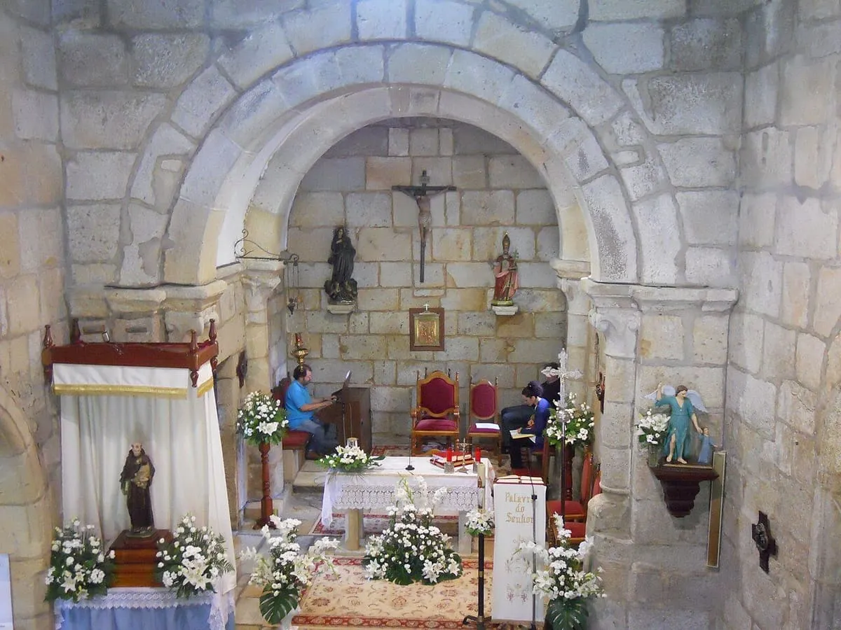 La capilla mayor de San Pedro de Baroña con arcos de medio punto y altar adornado