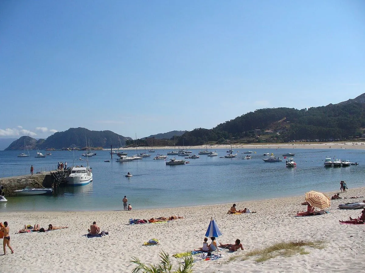 Playa de Rodas, de arena clara y con barcos fondeados, en las islas Cíes