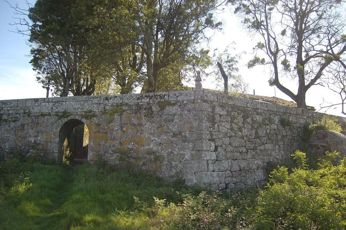 Muro de piedra de la antigua fortificación del monte da Peneda, con un arco bajo