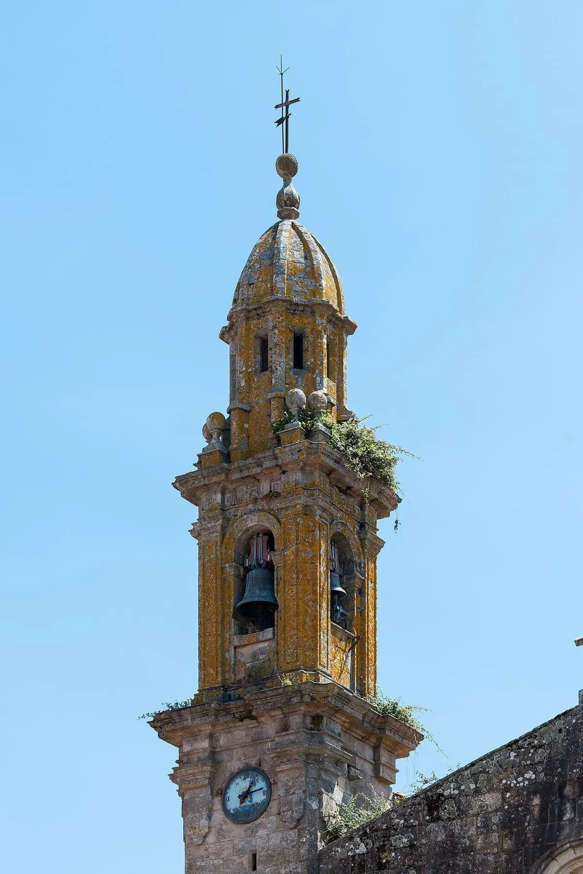 Campanario barroco de piedra de la iglesia de Santa Comba, con cúpula y pináculos