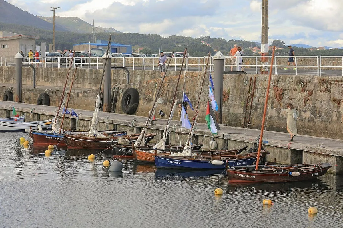 Dornas a vela amarradas junto al muelle del puerto de Ribeira