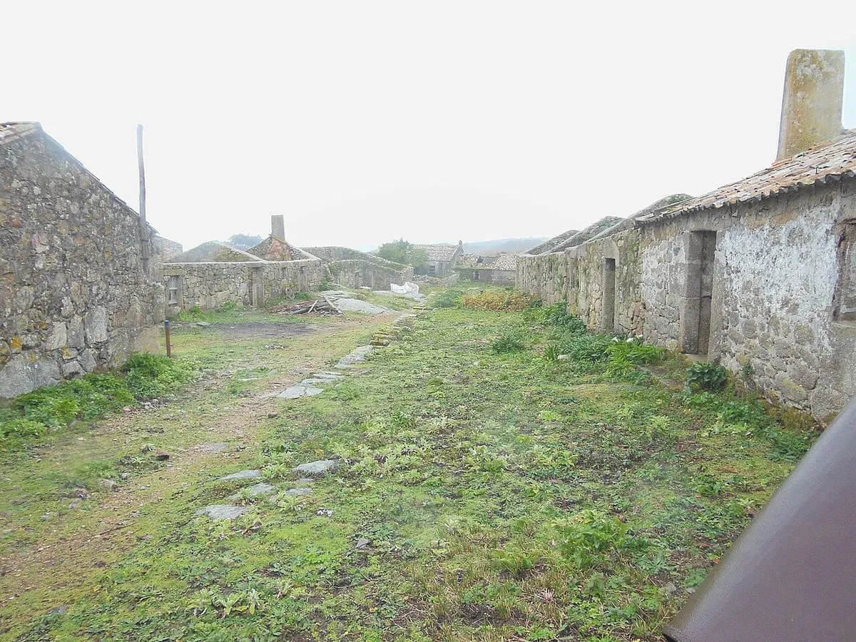 Calle de hierba entre las casas de piedra de la aldea abandonada de Sálvora