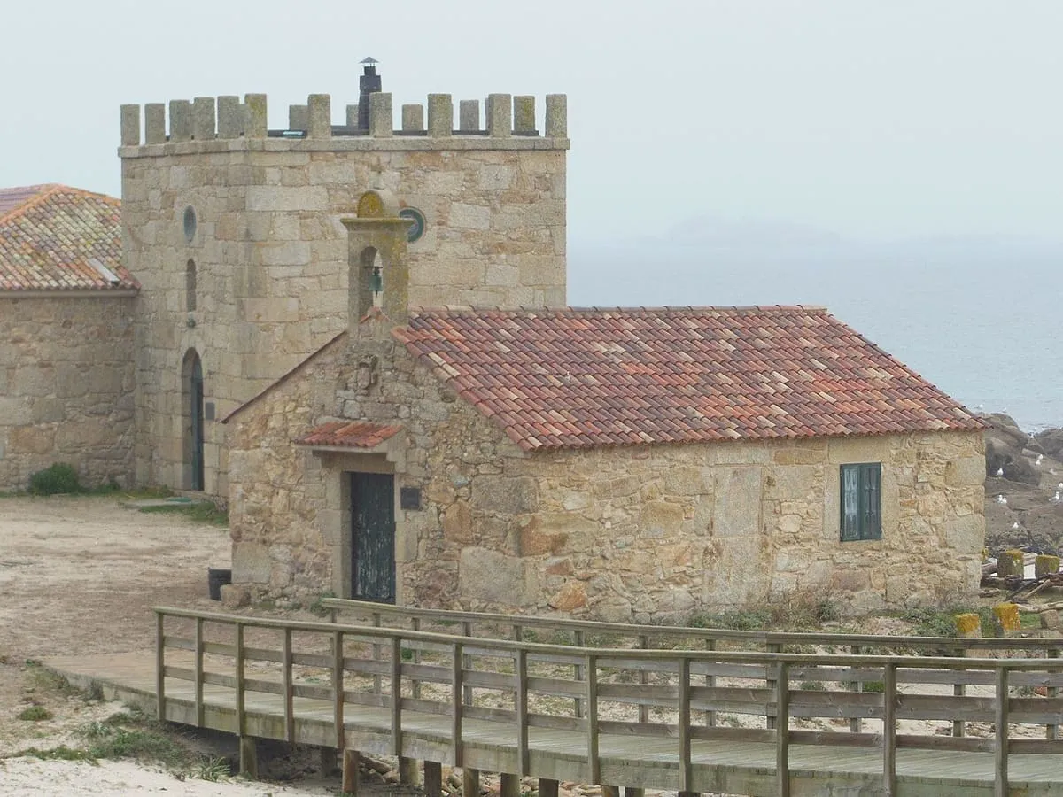 La capilla de Santa Catarina, de piedra y teja, junto a la torre almenada del almacén de Sálvora
