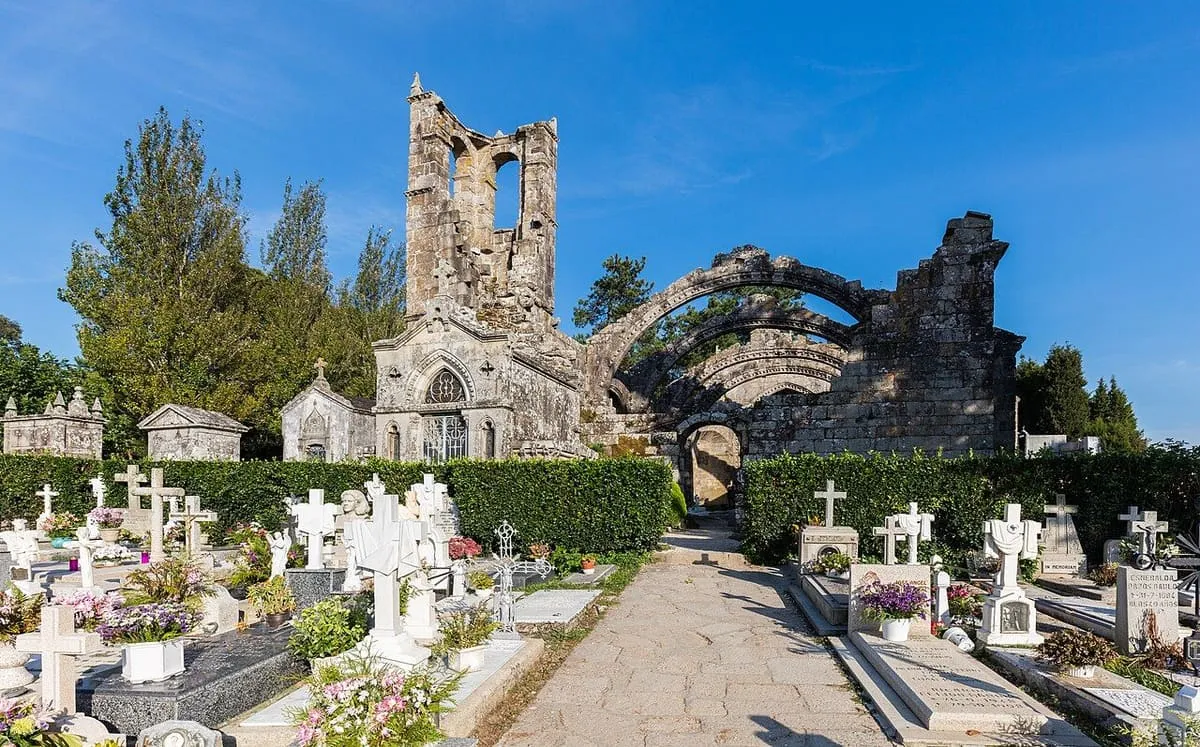 Ruinas góticas de Santa Mariña Dozo con la espadaña y las cruces blancas del cementerio en primer plano