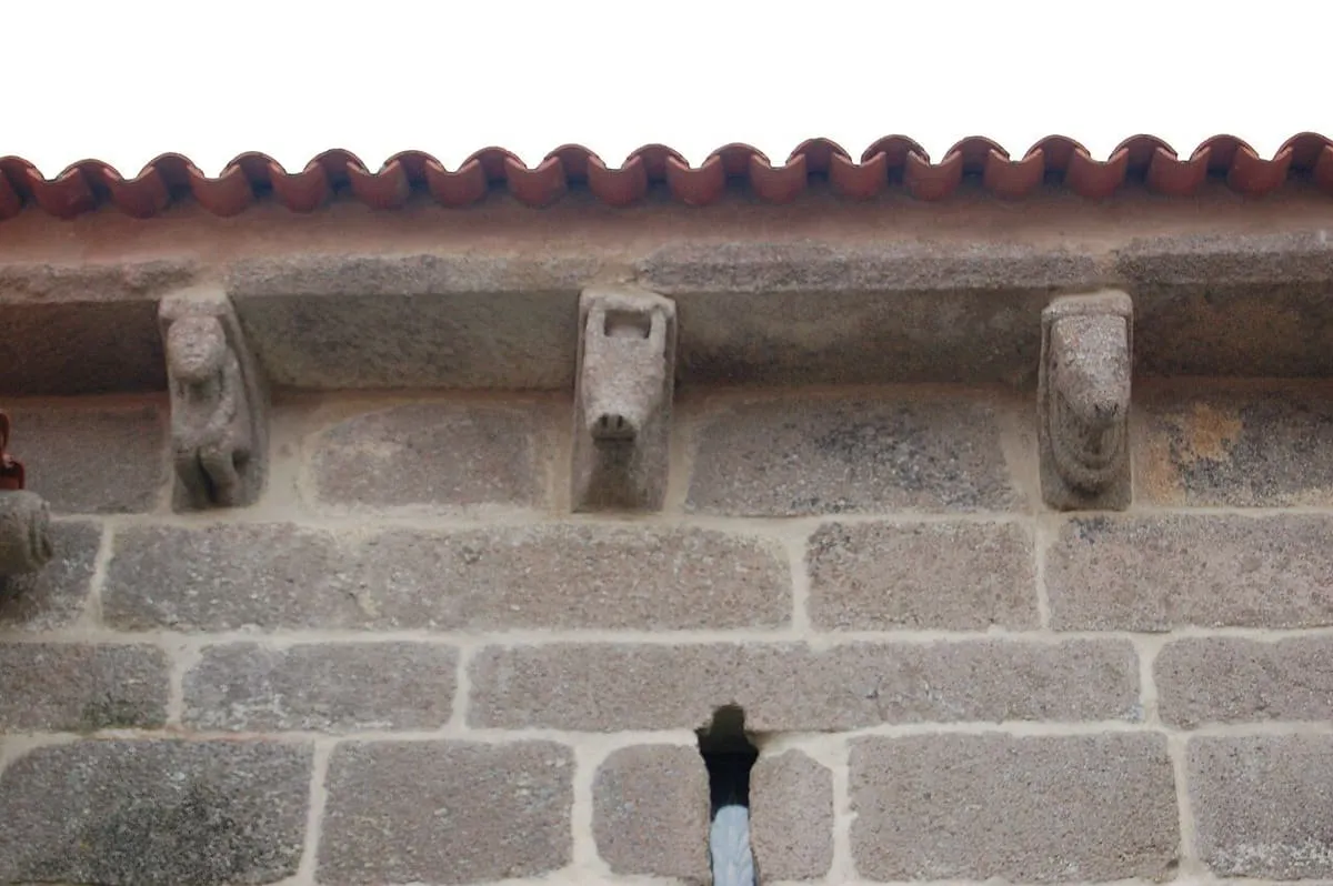 Canecillos románicos tallados bajo el alero de la nave de la iglesia de Adina