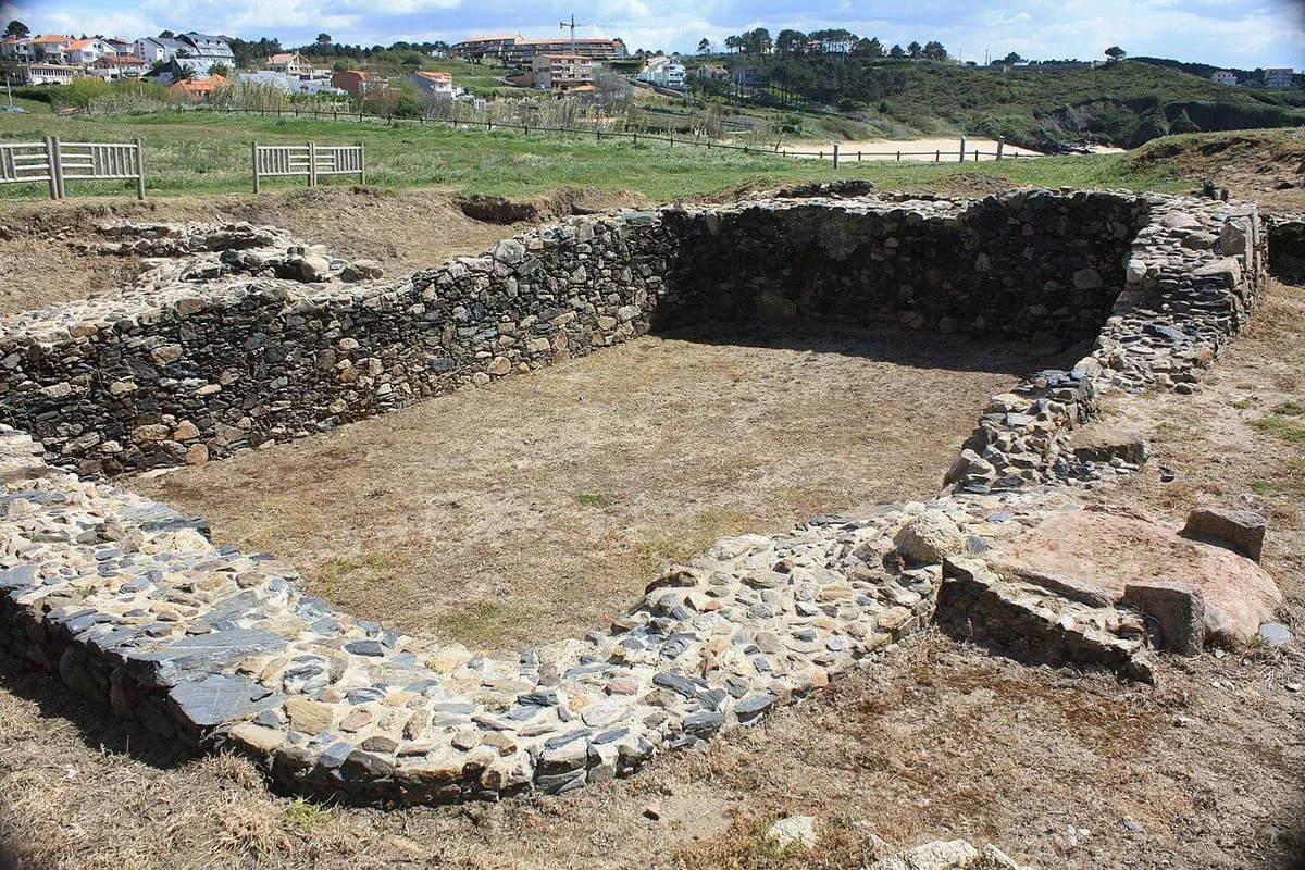 Cimientos de piedra de una vivienda del castro de la Lanzada excavados sobre la arena