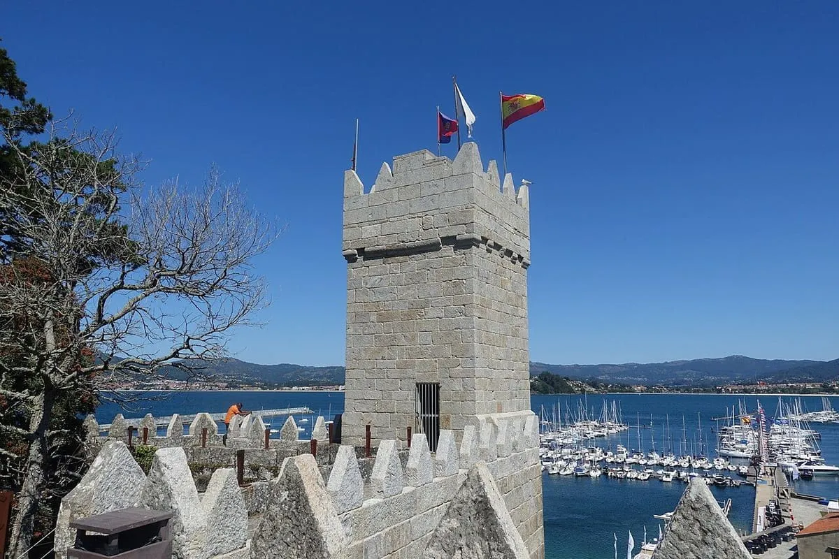 Torre del Reloj de Monterreal sobre las almenas, con el puerto de Baiona al fondo
