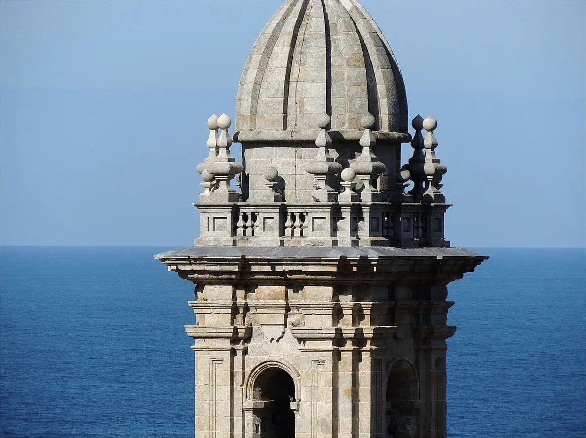 La torre barroca del monasterio recortada contra el océano