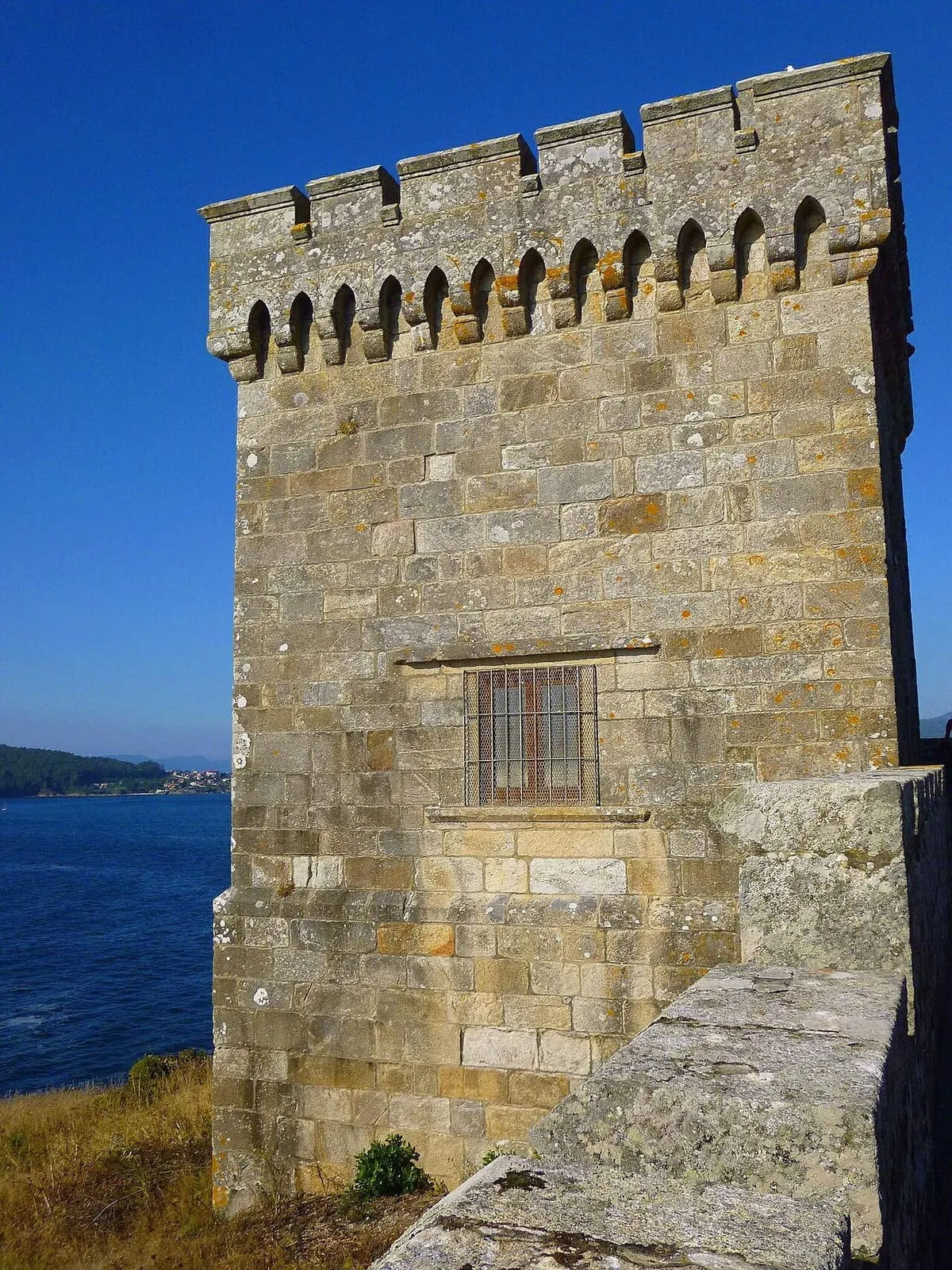 Torre de piedra de la muralla de Monterreal asomada al mar
