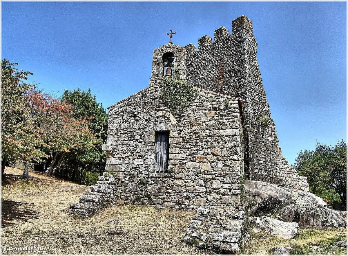 Torre medieval de piedra junto a una pequeña capilla, en las Torres do Oeste