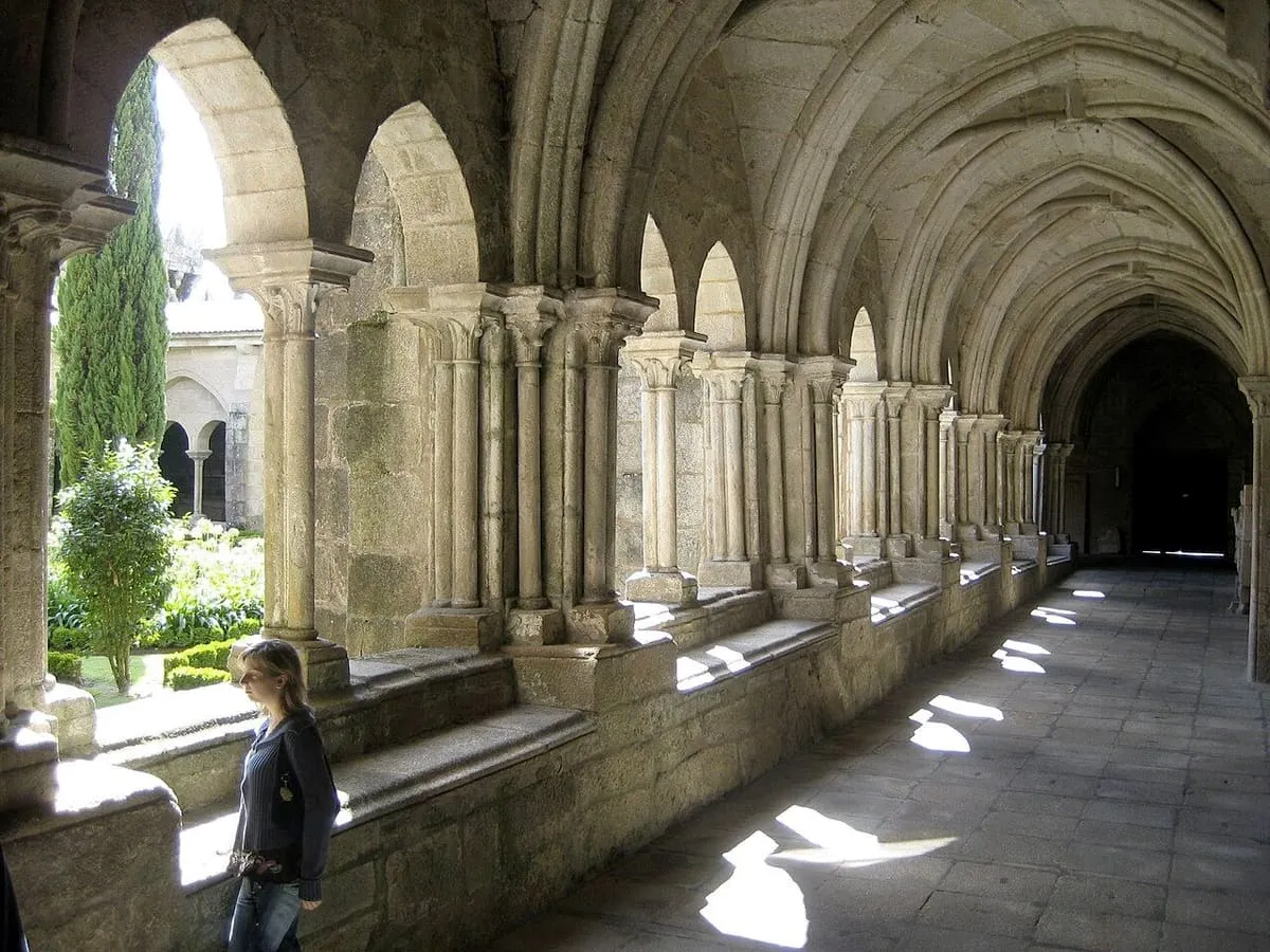 Galería gótica del claustro de la catedral de Tui, con arcos apuntados y un jardín al fondo