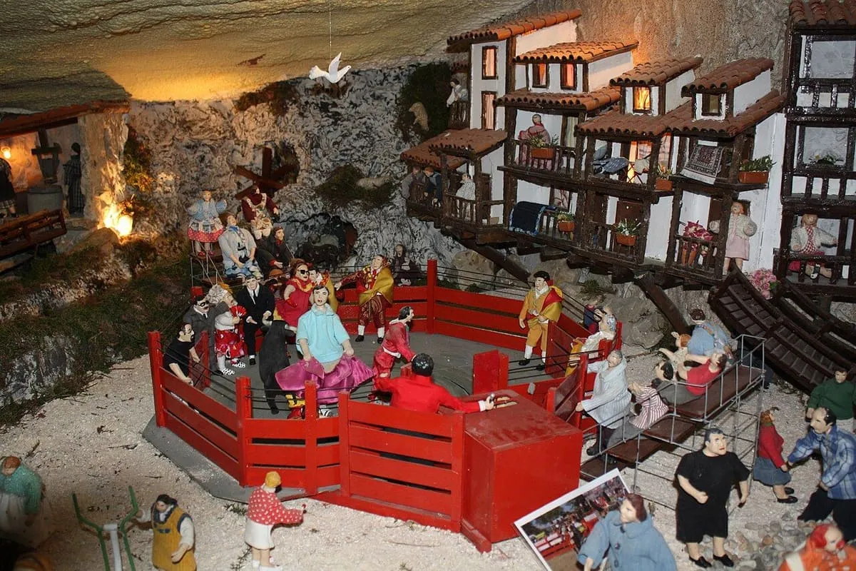 Escena de plaza de toros con figuras y casas de balcones de madera, en el Belén de Valga