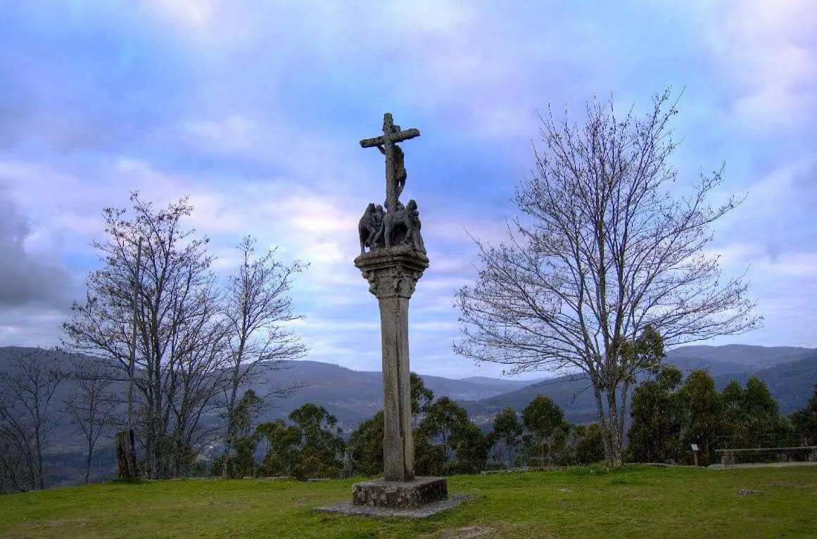 Un cruceiro en lo alto del castro de Troña, con las montañas del valle al fondo
