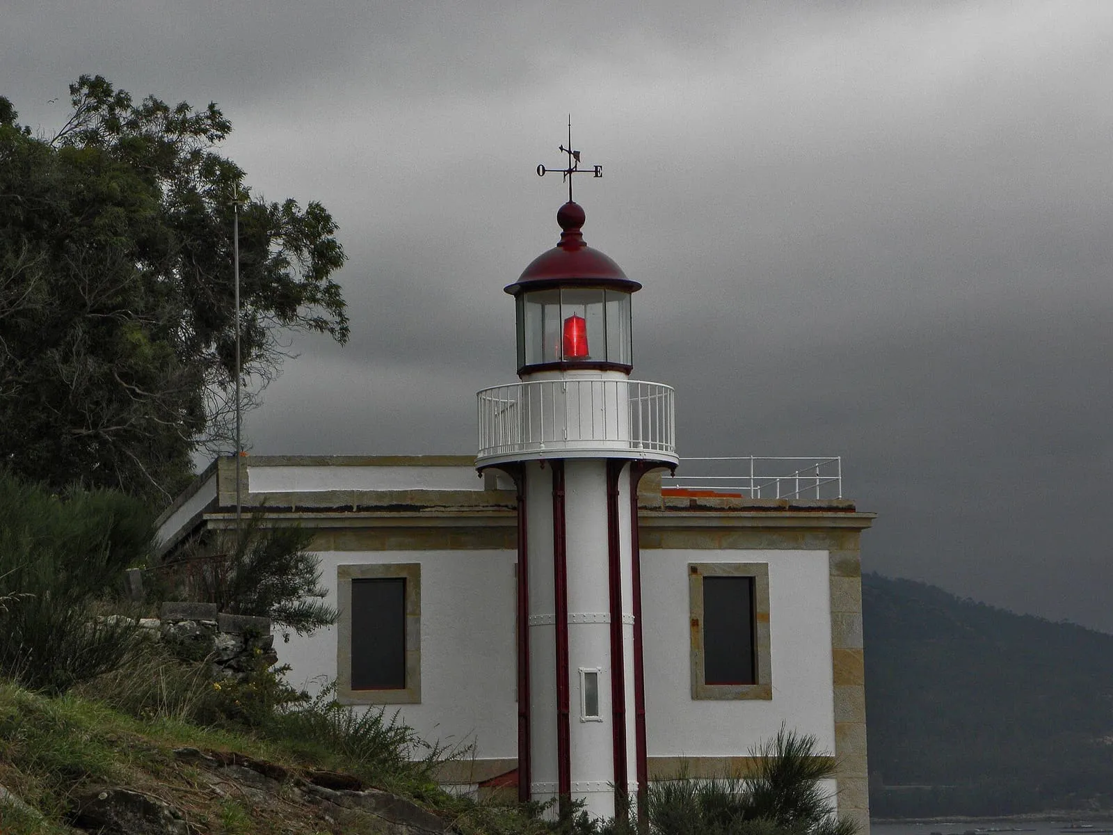 La baliza de cabo Rebordiño: una torre blanca con linterna roja junto a la casa del faro