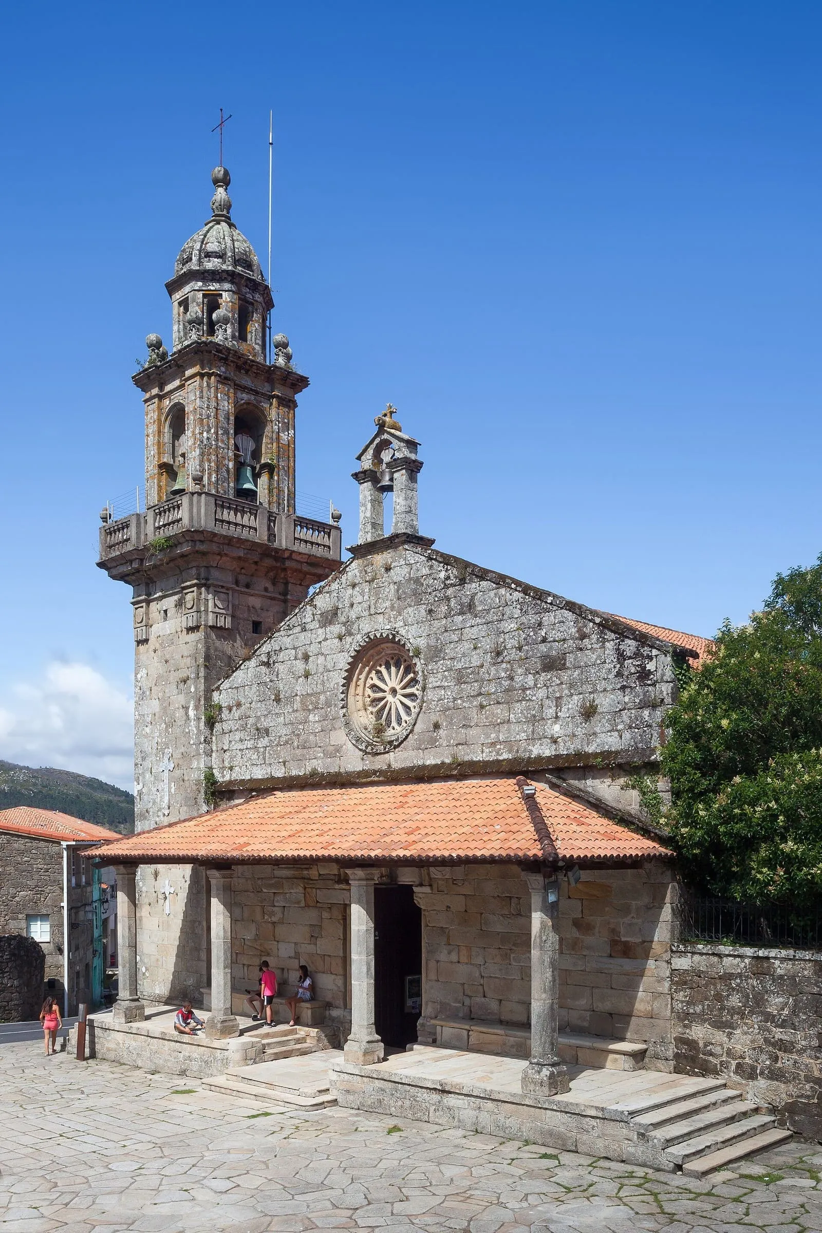 Iglesia de piedra con porche y campanario, la antigua colegiata de Santa María do Campo, en Muros