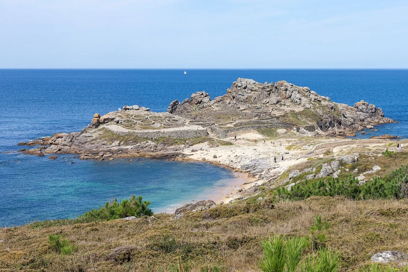 Castro de Baroña sobre una península de rocas rodeada por el mar y una playa de arena