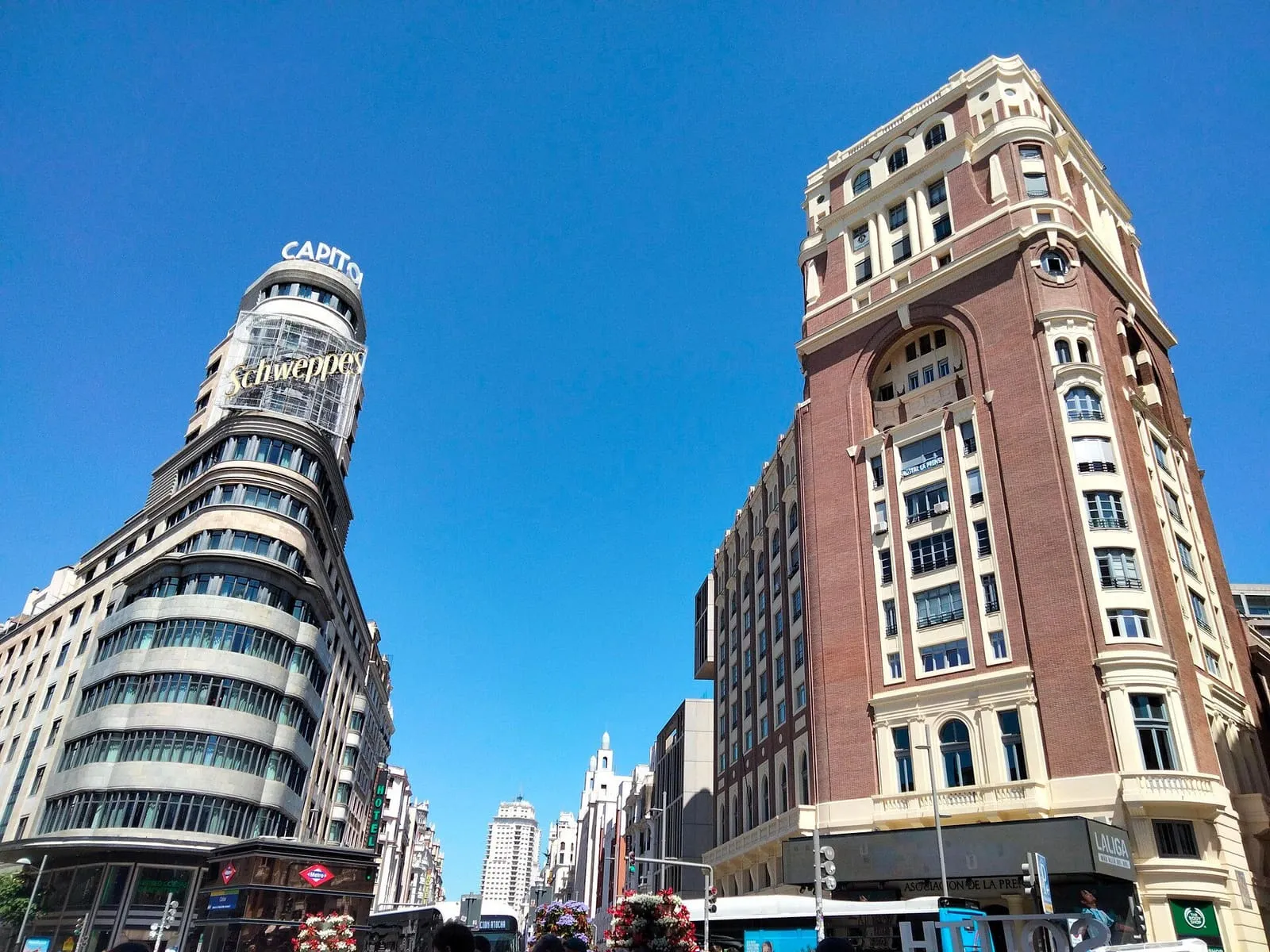Edificio Capitol y Palacio de la Prensa a ambos lados de la Gran Vía de Madrid, bajo un cielo despejado