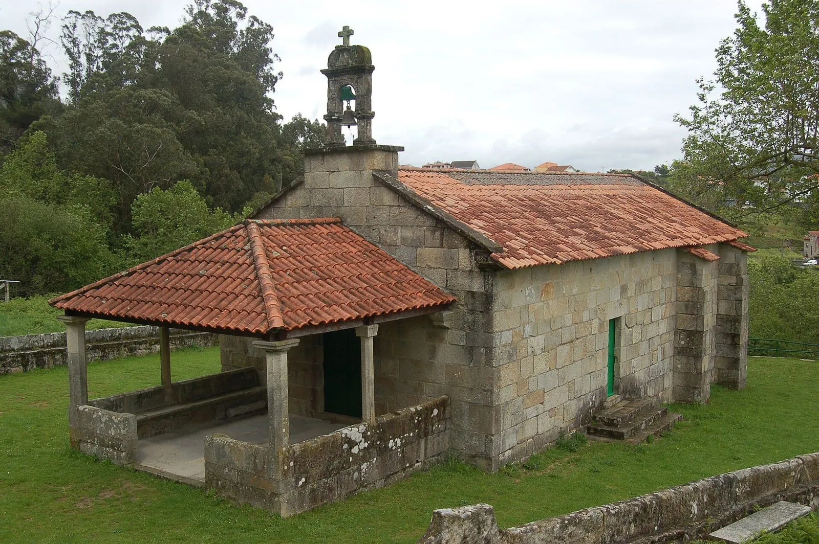 La capilla de la Virxe da Renda, de piedra y teja, con un porche de madera, en Combarro