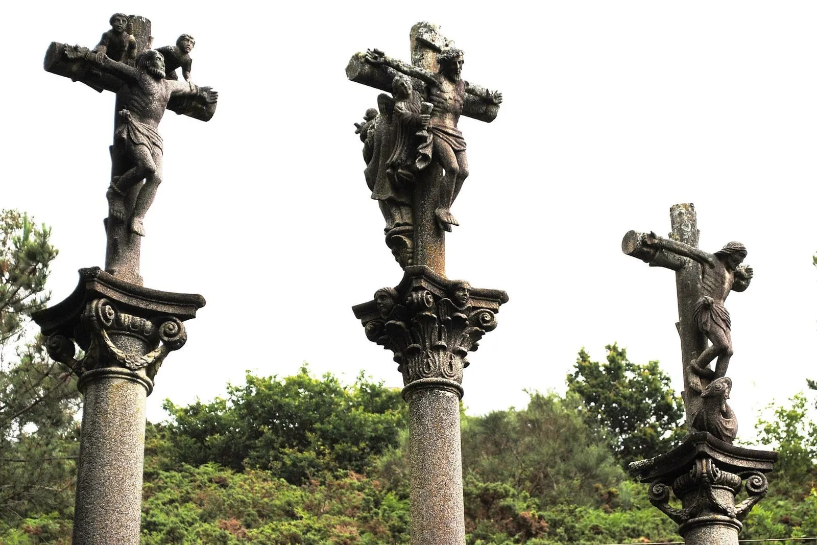 Los tres cruceiros del calvario de Castro Barbudo con sus cruces y capiteles, sobre un cielo claro