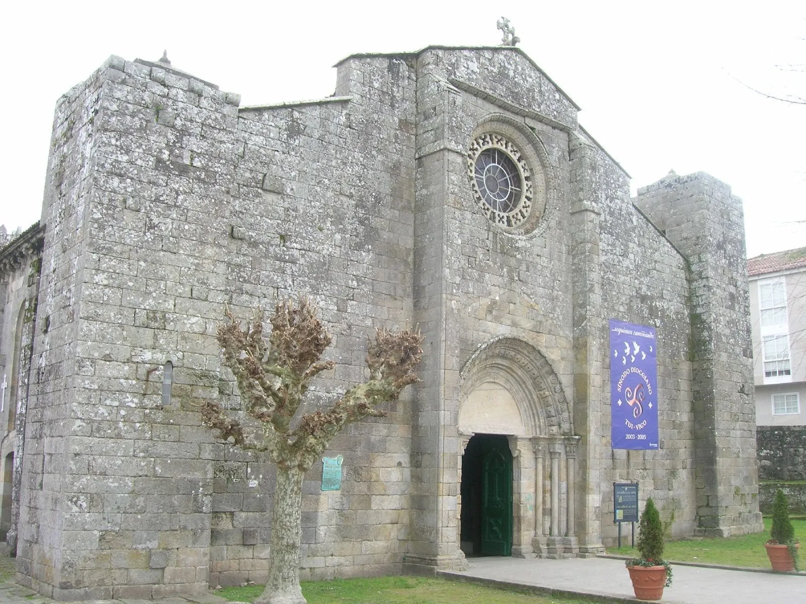 La fachada de piedra de la excolegiata de Santa María de Baiona, con rosetón y portada con arquivoltas