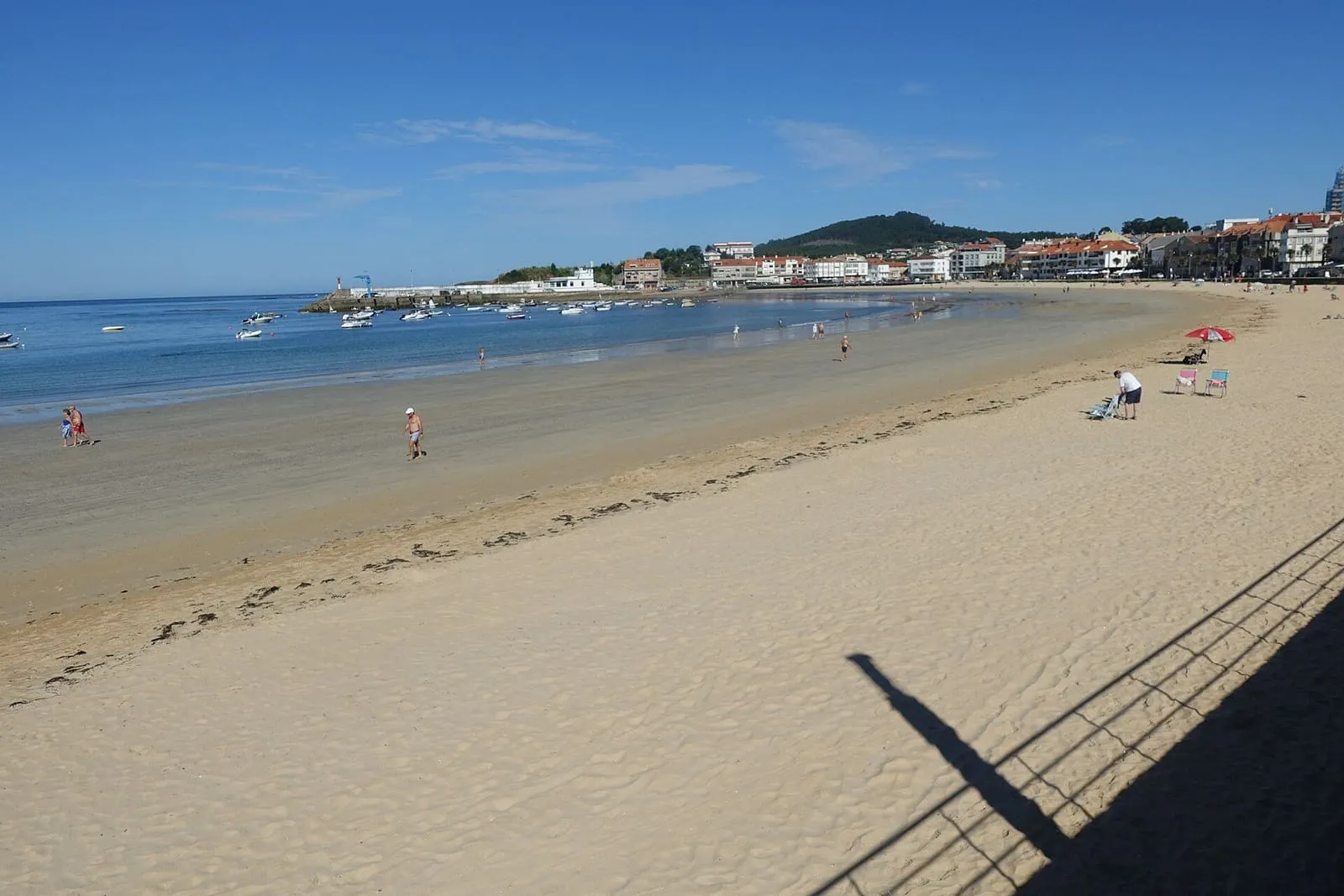 Playa de Panxón con arena fina y el pueblo y el puerto al fondo