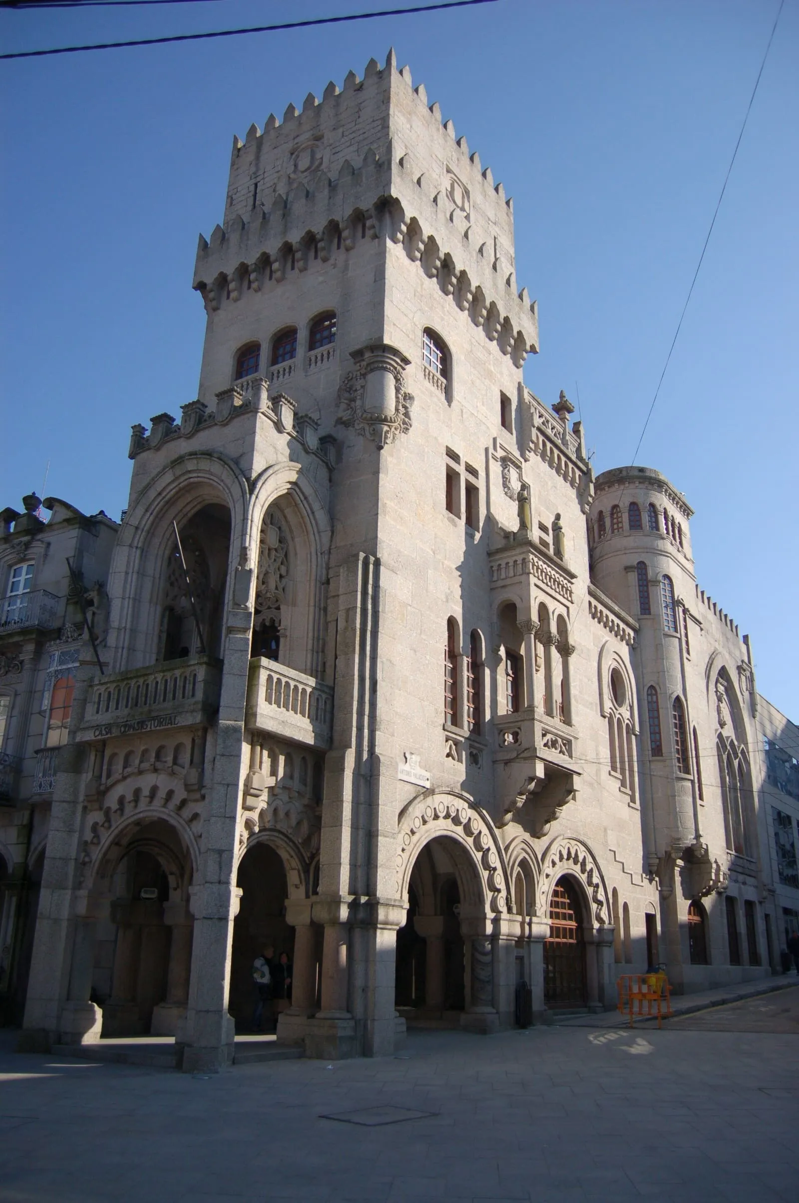 Fachada de granito de la casa consistorial de O Porriño con arcos y torre