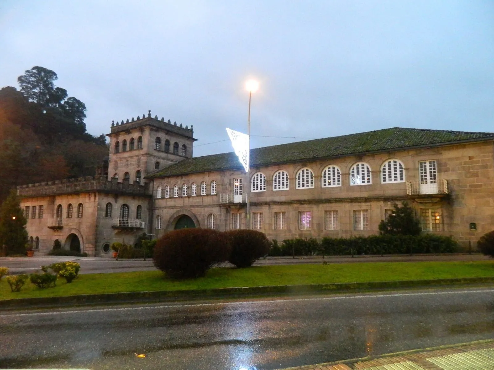 Fachada del conjunto del convento de Vilavella, con torre y ventanales, al anochecer