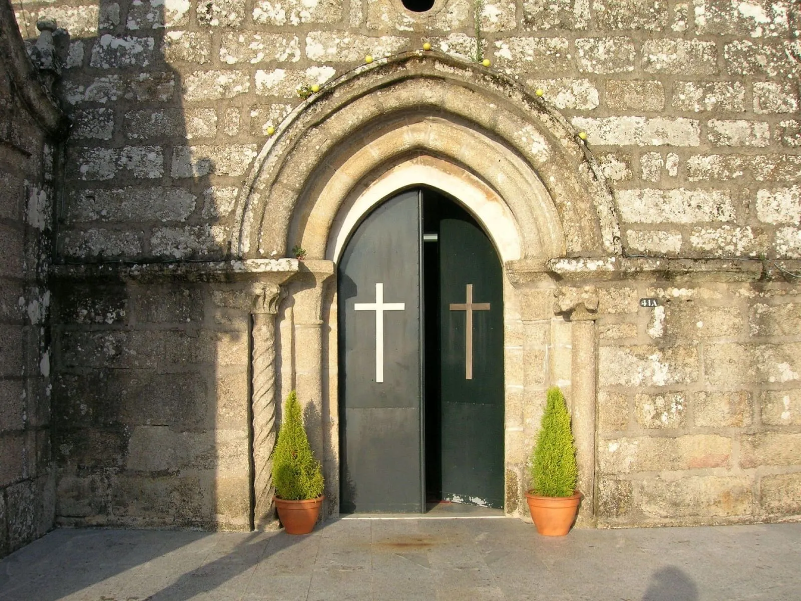 Portada románica de la iglesia de Santiago de Arcade con puerta verde y arquivoltas